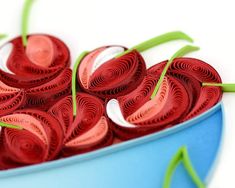 a blue bowl filled with red paper flowers