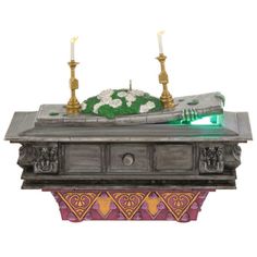 an elaborately decorated table with two candles on it and a green light in the middle