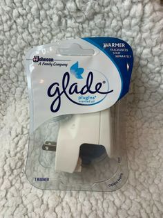 a package of glade plugs sitting on top of a white blanket