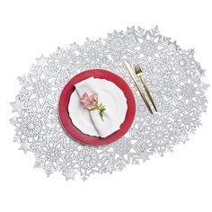 a white plate topped with a pink flower next to a fork and knife