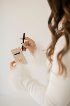 a woman holding a note and pen in her right hand