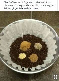 a metal bowl filled with food on top of a tiled floor next to a cell phone