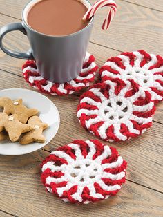 red and white crocheted coasters next to a cup of coffee with candy cane