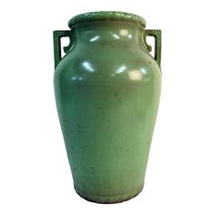 a large green vase sitting on top of a white surface