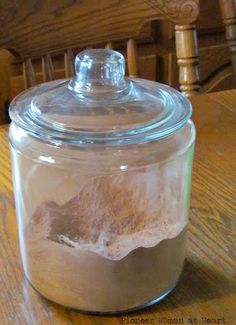 a glass jar filled with sand on top of a wooden table