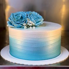 a cake with blue frosting and flowers on top