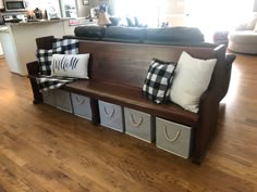 a wooden bench with several storage bins on it's side in a living room