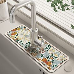 a kitchen sink with a floral design on the front and side, next to a window