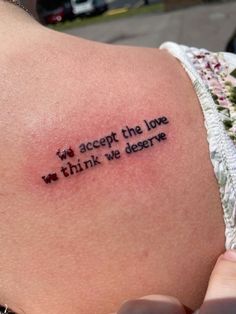 a woman with a tattoo on her shoulder that says, accept the love we think we deserves