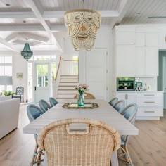 a dining room table with wicker chairs and a basket on the back of it