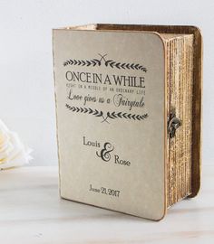 an open book sitting on top of a table next to a vase with white flowers