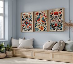 three paintings hang on the wall above a wooden bench with pillows and plants in vases