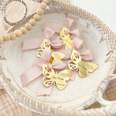 some pink and gold butterflies on a white plate