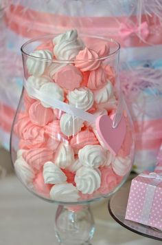 a glass filled with lots of pink and white candy