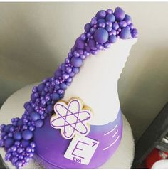 there is a purple and white vase with beads on the top that has an e in it