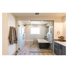 a bath room with a tub a sink and a mirror