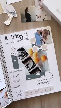 a baby is on the page next to an open notebook with pictures and other items