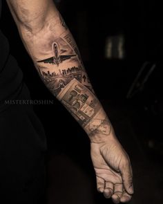 a man's arm with an airplane and money tattoo on the left hand,