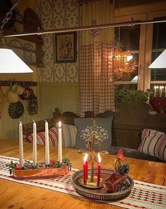 candles are lit on a table in the middle of a room with striped rugs