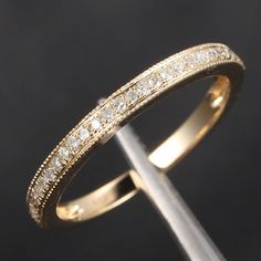 an image of a gold wedding ring with diamonds on the inside and outside, in front of a black background