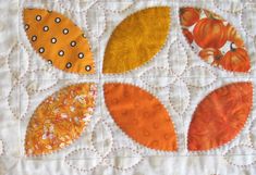 an orange and white quilt with different designs on it