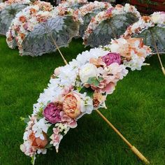 several umbrellas with flowers on them sitting in the grass