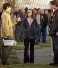 the young man is talking to his friends on the side walk in front of him