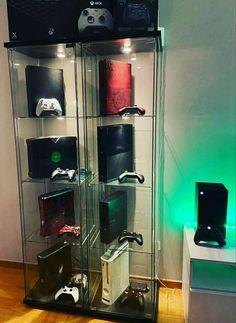 a display case filled with lots of different types of video game controllers on top of glass shelves