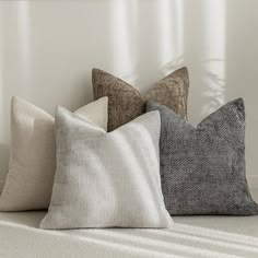 four pillows sitting on top of a white couch