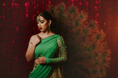 Sadia - Contemporary Asymmetrical Green Bridal Saree Style Lehenga with pearl work Look like a modern bride of today's time and take the dance floor by storm in this unique ensemble saree like lengha! Asymmetric one-shoulder designer blouse with pre draped feature & pearl work Georgette fabric used to give you the benefit of a good drape feature Modern single-shoulder detail with pre draped saree like pleats makes this piece an absolute stunner Interesting crystal beadwork runs all over neckline Party Sharara With Tilla And Traditional Drape, Bollywood Style Pre-draped Saree With Tilla For Festivals, Festive Tilla Pre-draped Saree, Bollywood Style Pre-draped Tilla Saree For Festive Occasions, Traditional Pre-draped Tilla Saree For Festivals, Bollywood Style Festive Pre-draped Saree With Tilla, Festive Bollywood Pre-draped Saree With Tilla, Wedding Pre-draped Saree For Navratri, Anarkali Pre-draped Saree With Tilla For Wedding