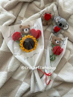 two teddy bears are wrapped in white paper and tied with red, yellow and green flowers