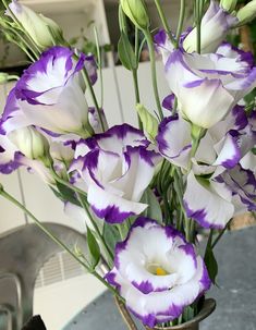 a vase filled with purple and white flowers