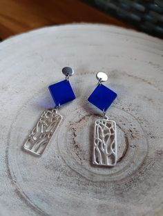 These elegant earrings are handcrafted with blue resin and silver accents, featuring a unique geometric design. Perfect for adding a touch of sophistication and modern style to any outfit, these earrings are ideal for any occasion, from formal events to casual outings. Characteristics: Material: Resin, silver metal Color: Blue with silver details Length: [Specify measurements] Handmade Light and comfortable to wear Perfect for any occasion Careful: To keep your earrings in perfect condition, avoid contact with water and chemicals. Store them in a dry and safe place. Modern Blue Earrings For Party, Trendy Blue Sterling Silver Earrings, Modern Geometric Blue Jewelry, Modern Blue Geometric Jewelry, Handmade Blue Geometric Earrings, Modern Blue Metal Earrings, Formal Blue Metal Earrings, Modern Blue Metal Jewelry, Elegant Blue Geometric Jewelry