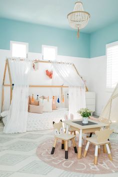 a child's bedroom decorated in pastel blue and white with a canopy bed