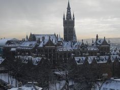 a large building with a clock tower in the middle of it's roof tops