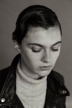 a woman with her eyes closed wearing a leather jacket