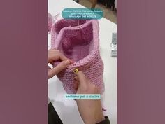 someone is knitting a pink crocheted purse