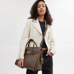 Our Broome has all the effortless cool of its namesake Soho street. The spacious foldover silhouette is crafted of luxe refined leather with a high shine finish and secures with our pushlock “C” closure. Featuring pockets inside and out for easy organization and room for a 16” laptop carry it by hand or use the detachable strap to wear it crossbody. | Coach Broome Carryall Bag 36 - Women's - Brass/dark Stone Soho Street, Crossbody Coach, Easy Organization, Carry All Bag, Tote Handbags, Soho, Inside Pocket, Carry On, Women Handbags