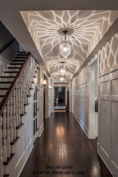 an empty hallway with stairs and lights on the ceiling is pictured in this image from the front door