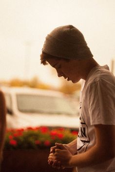 a young man standing in front of a white van