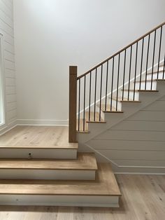 an empty room with wooden steps and white walls