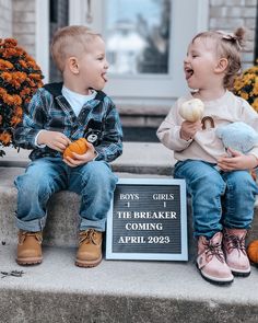 two young children sitting on steps eating pumpkins