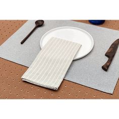 a place setting with white plates and utensils on a brown tableclothed surface