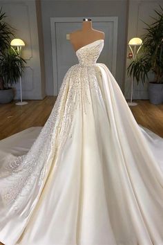 a white wedding dress on display in a room