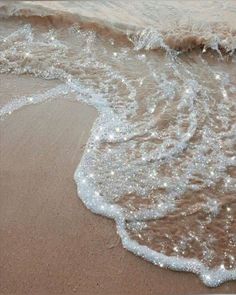 an ocean wave is coming in to the shore and it looks like they're getting wet