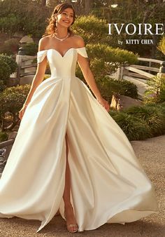 a woman in a white dress posing for the camera