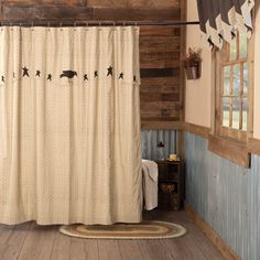 a bathroom with wood paneling and a shower curtain that has black birds on it