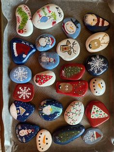 a box filled with lots of different types of painted rocks on top of a table