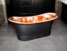 a bathroom with a black and gold bathtub