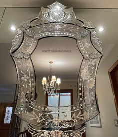 an ornate mirror with chandelier hanging from the ceiling